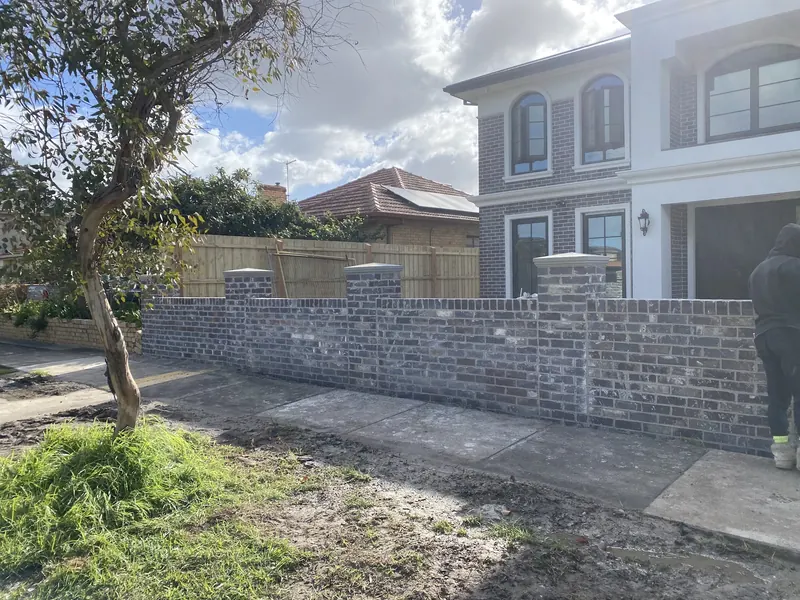 Grey brick front fence with capped piers