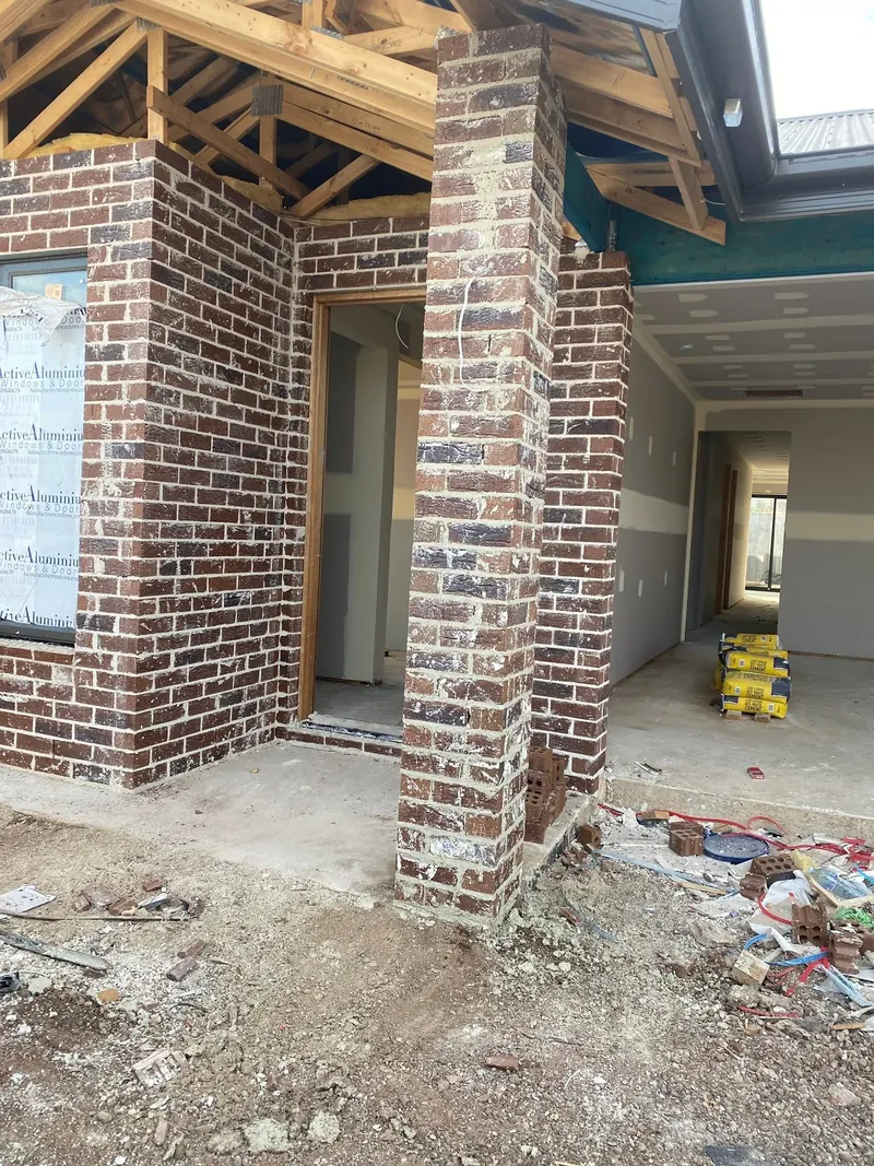 Red brick porch pier and walls under a timber-framed roof