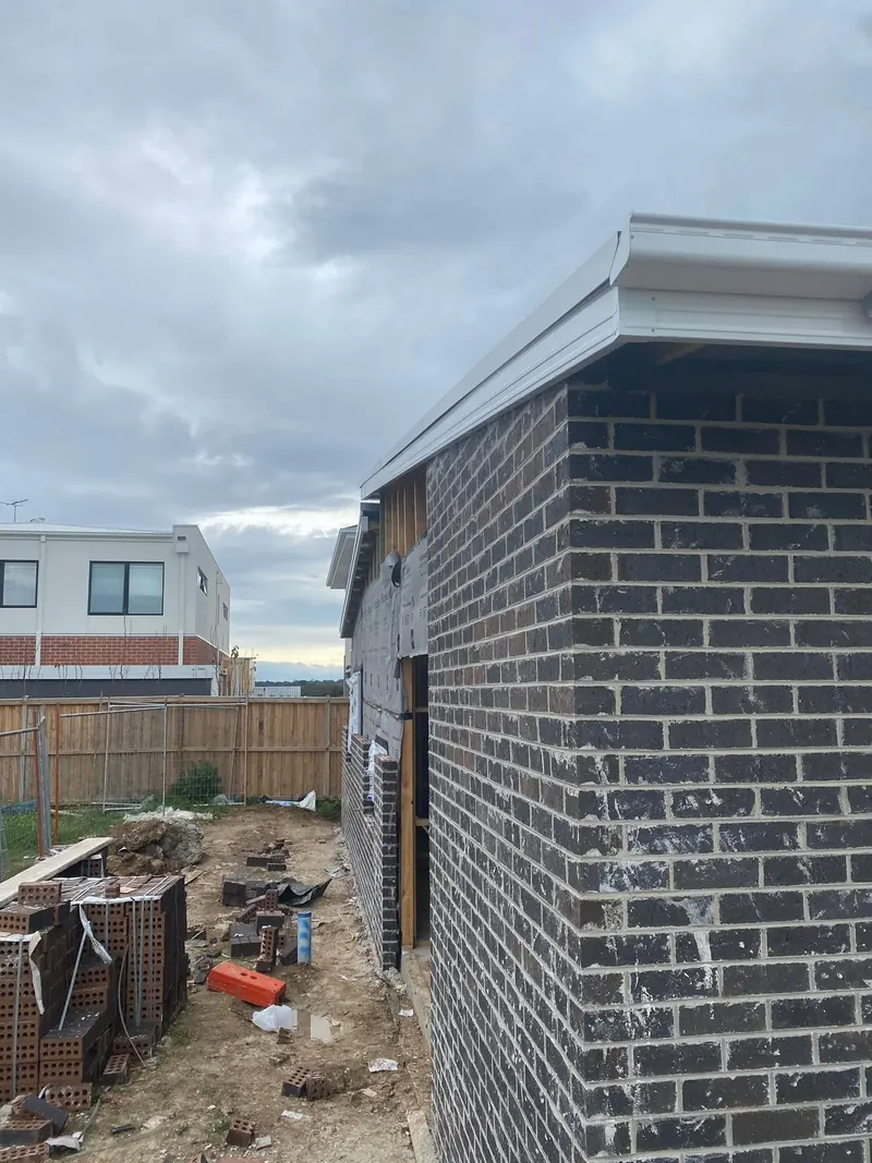 Dark brick house corner under the eave