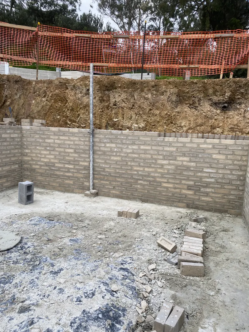 Concrete block retaining wall cut into a bank