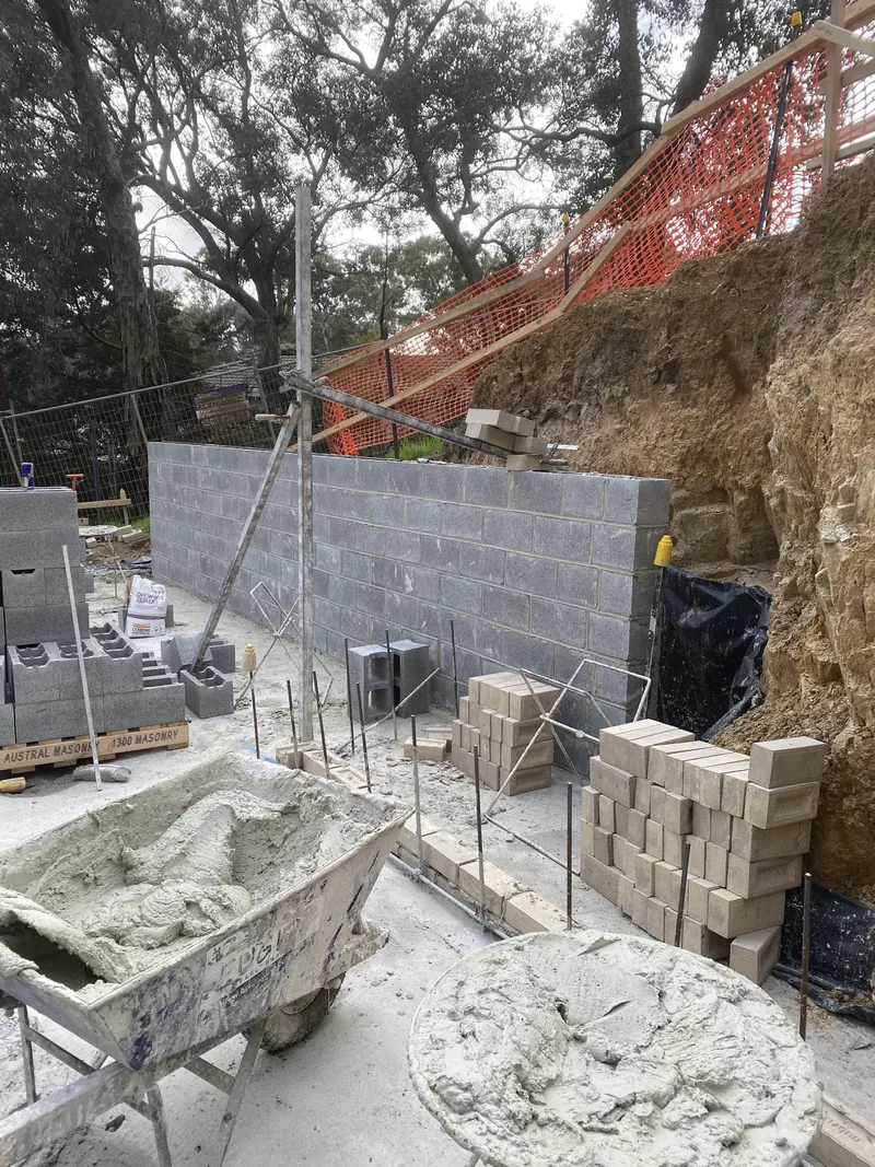 Retaining blockwork with a wheelbarrow and mortar board